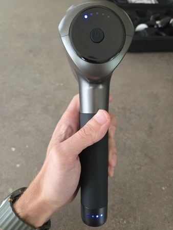 Northwall G1 massage gun in hand met aan en uit knop en intensiteit regelaar, getest door fysioengezond.nl