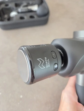 Northwall G1 massage gun in hand met hot cold opzetstuk, getest door fysioengezond.nl