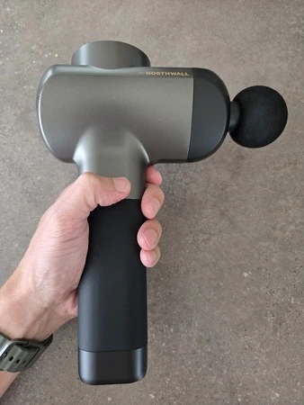 Northwall G1 massage gun in hand met bolkop opzetstuk, getest door fysioengezond.nl