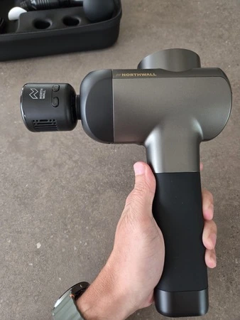 Northwall G1 massage gun in hand met hot cold opzetstuk zijaanzicht, getest door fysioengezond.nl