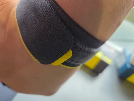 Push Sports elleboogbrace dragend om elleboog links onder aanzicht, getest door fysioengezond.nl